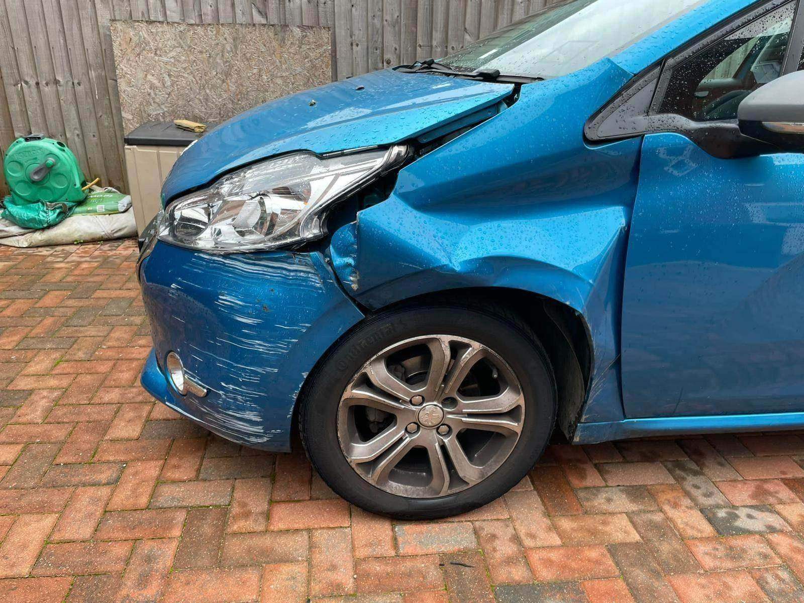 A car photographed before repair, with damage to the front wing and bumper