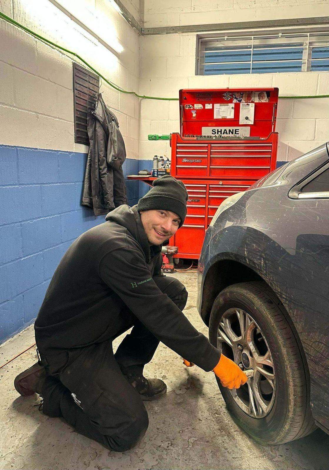 A technician working at a road wheel